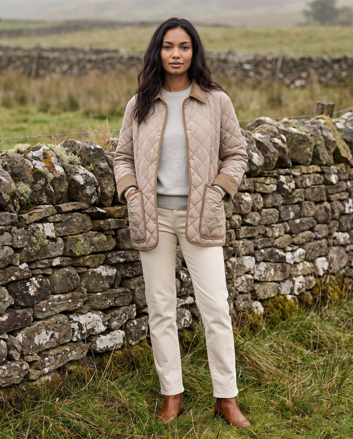 Veste matelassée à col velours côtelé Talia en Beige, portée devant un mur de pierre sèche, portée ouverte