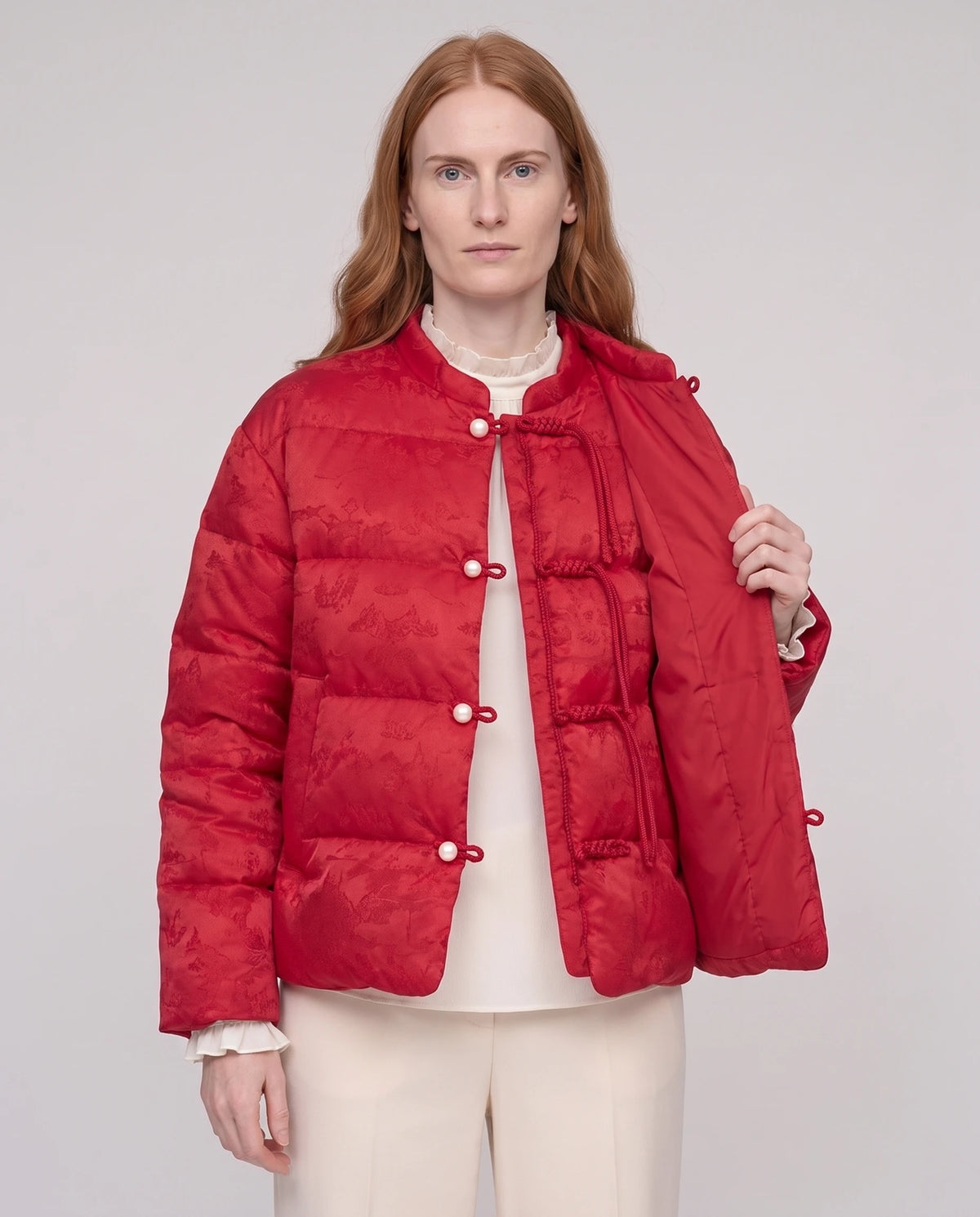 Veste matelassée jacquard à brandebourgs et col officier Dahlia rouge profond, portée ouverte sur un chemisier ivoire, plan rapproché