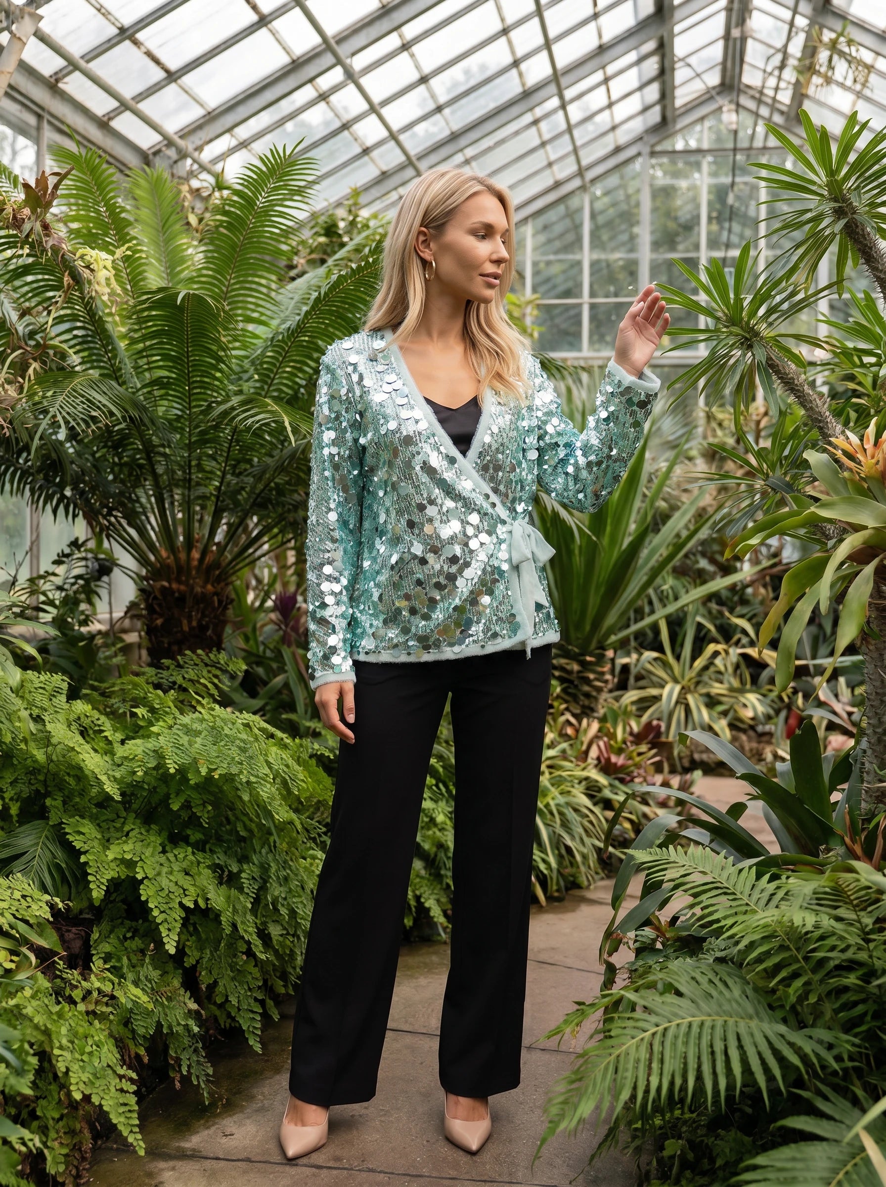 Veste à paillettes vert d'eau Félicie, portée dans un jardin d'hiver sous verrière