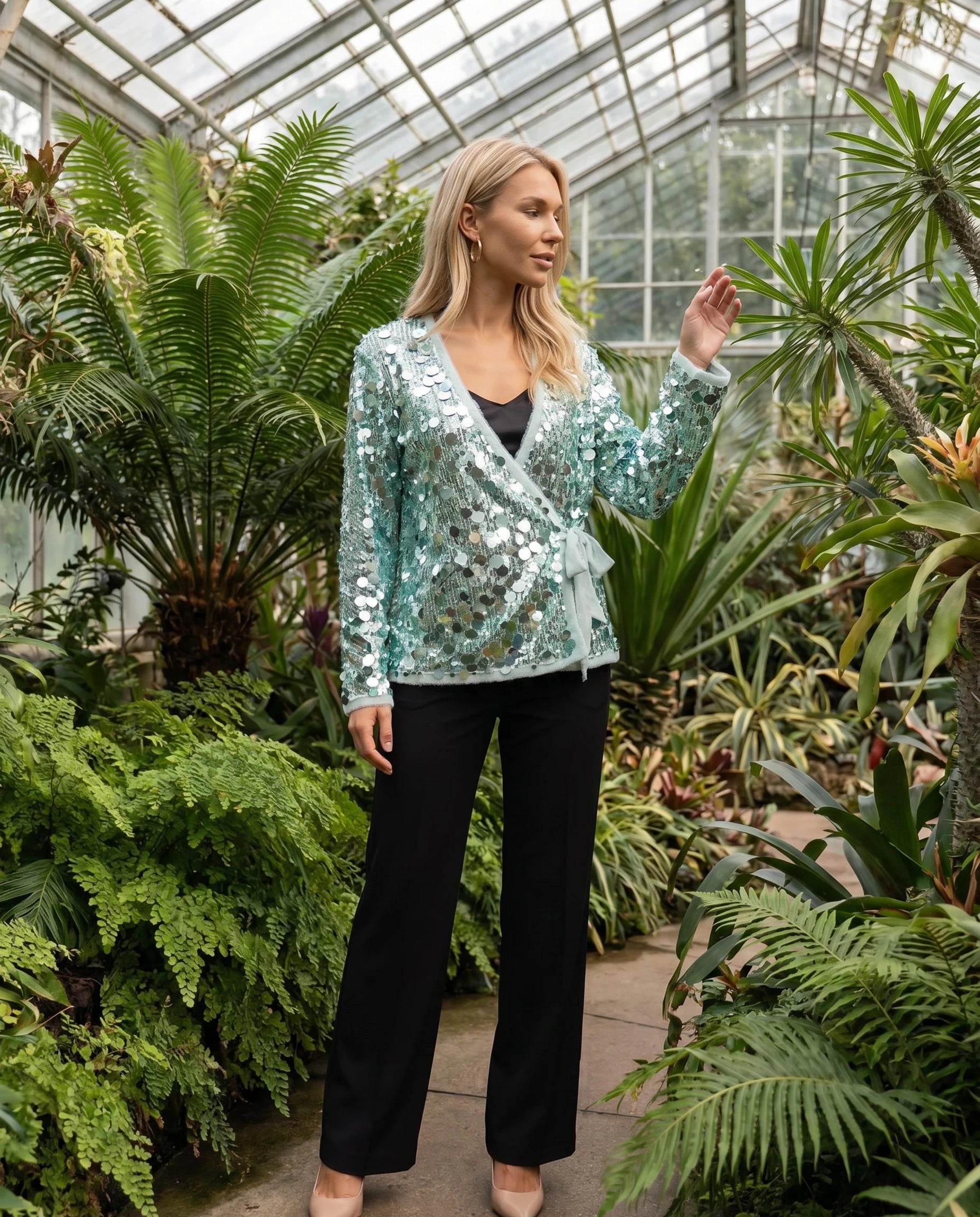 Veste à paillettes vert d'eau Félicie, portée dans un jardin d'hiver sous verrière