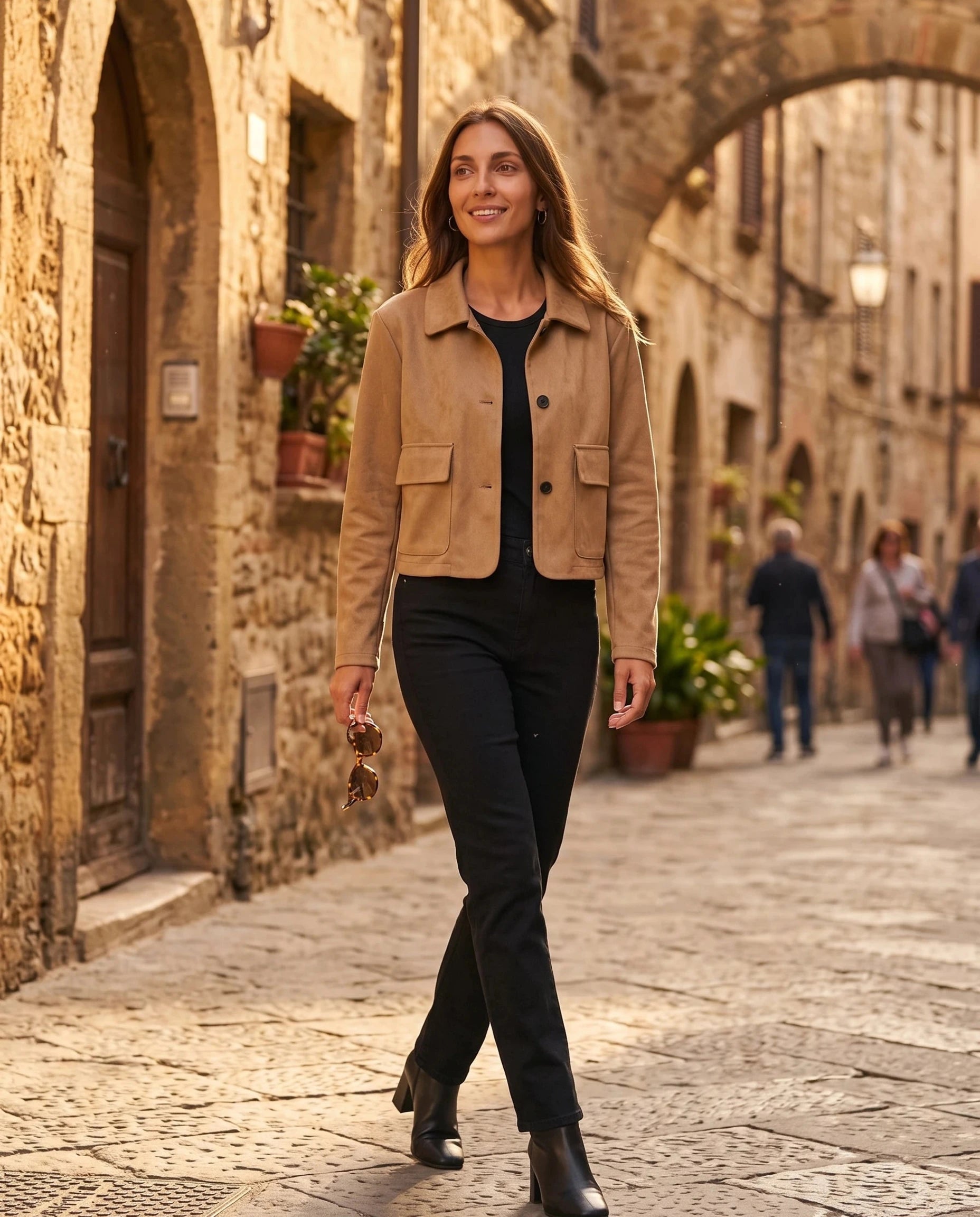 Veste en suédine camel Antonine, portée dans une vieille rue de pierre dorée
