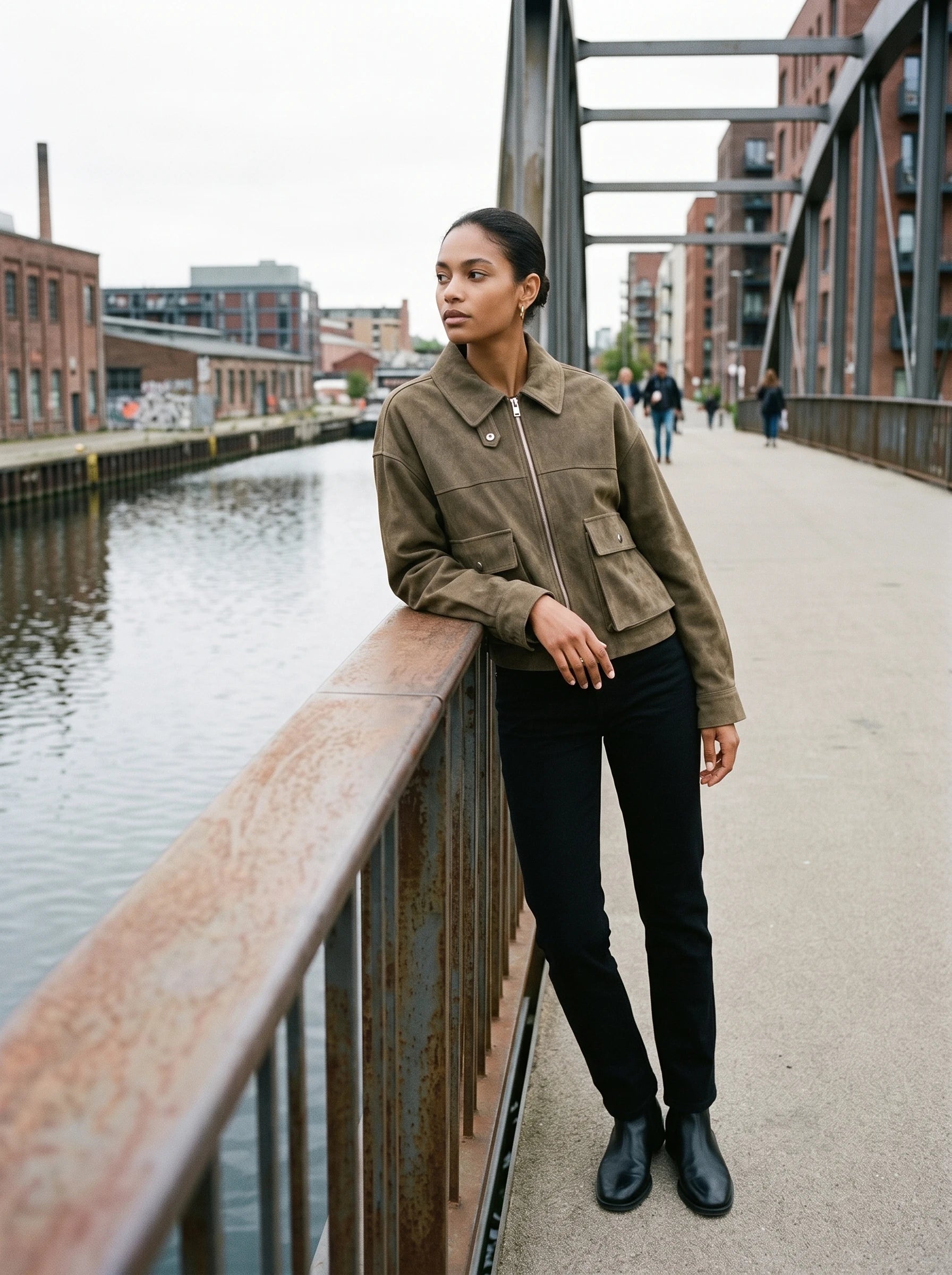 Veste utilitaire kaki Ernestine, portée sur une passerelle au-dessus d'un canal