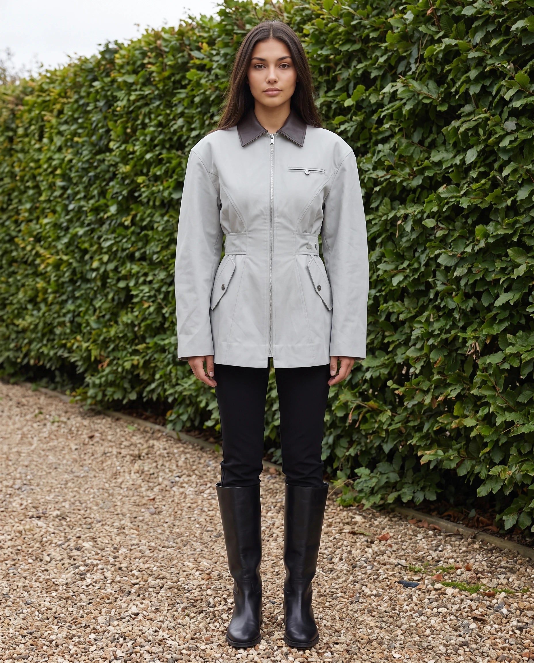 Veste zippée à taille cintrée gris perle Candice, en plein pied dans un jardin